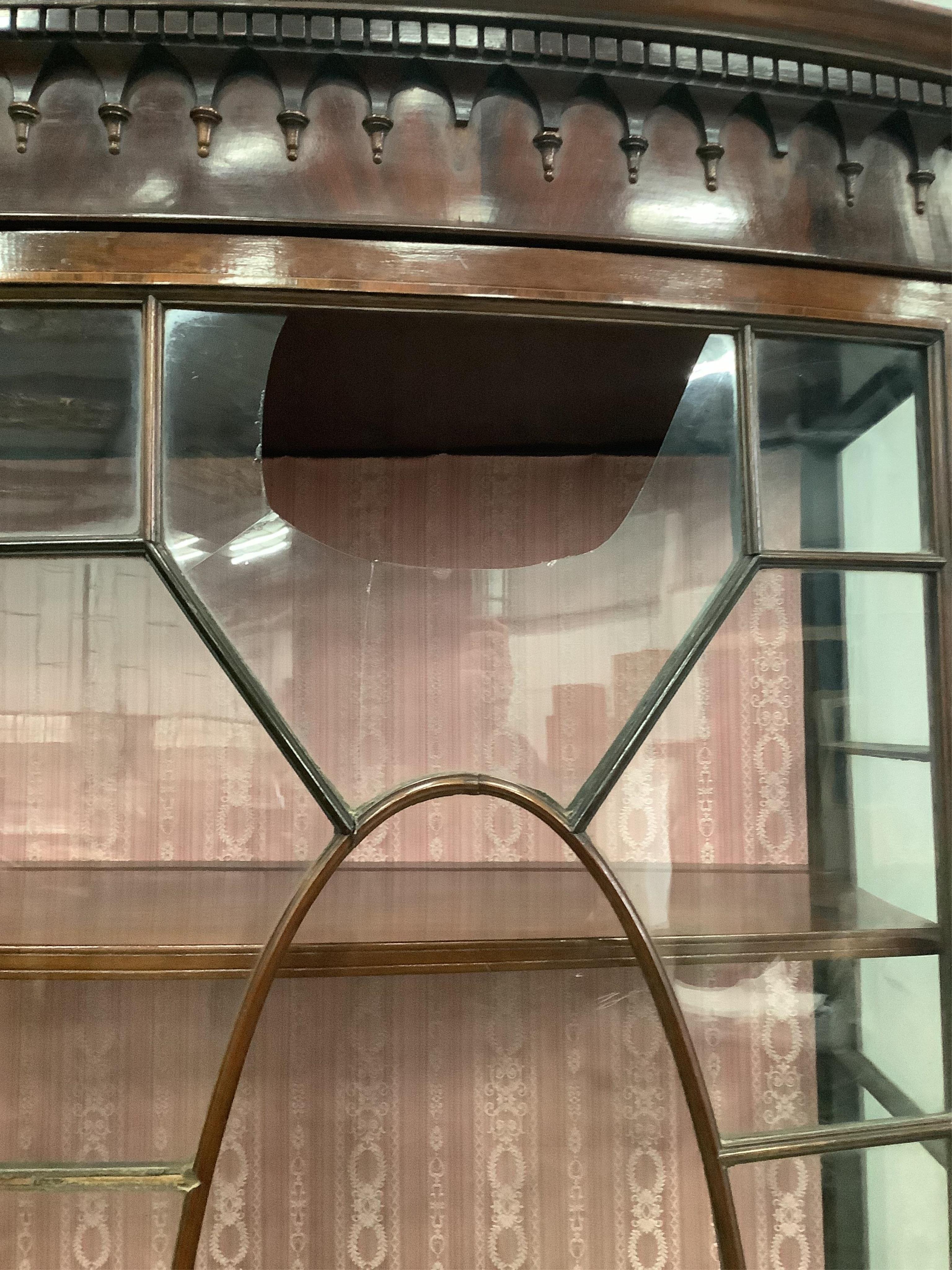 An Edwardian Sheraton style mahogany bow front display cabinet, width 126cm, depth 40cm, height 198cm. Condition - poor, one glass pane damaged